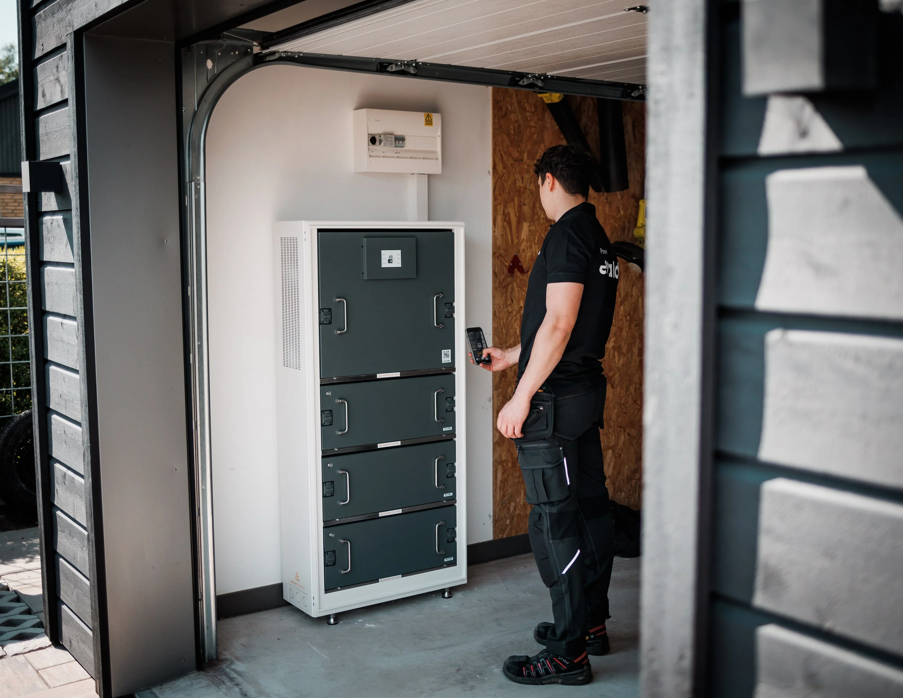 Montör bygger upp ett batteritorn i ett garage