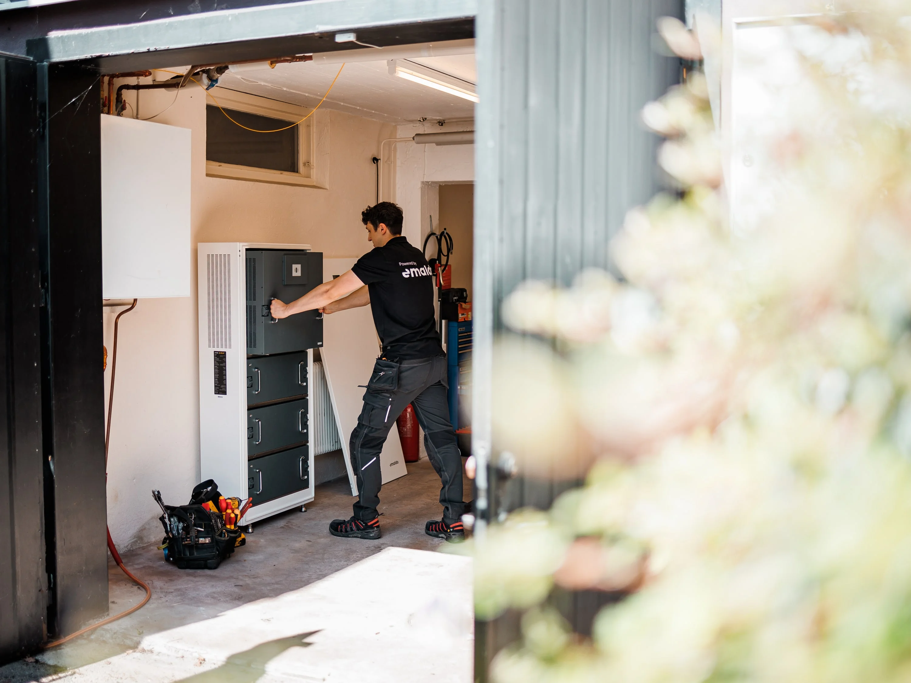 Montör installerar ett batteri i ett garage